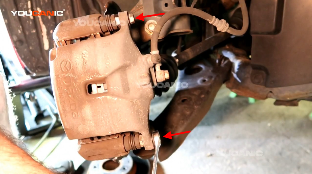 Removing the 13mm bolts on the piston caliper.