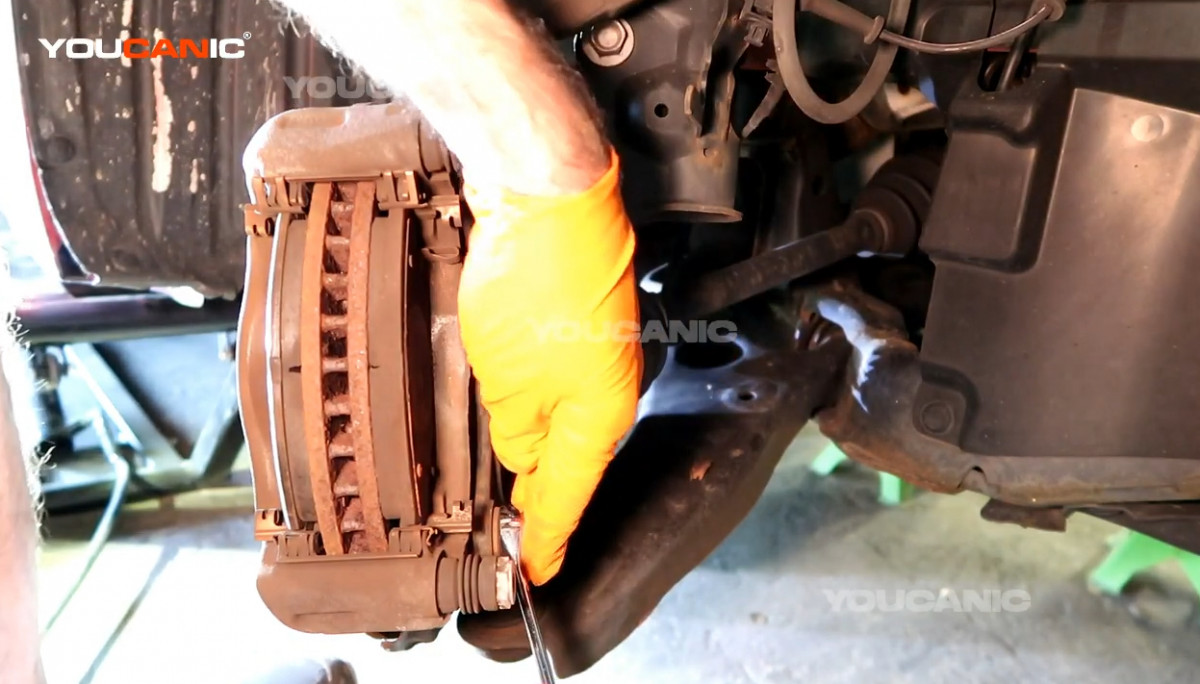 Removing the 17mm bolts on the caliper carrier.