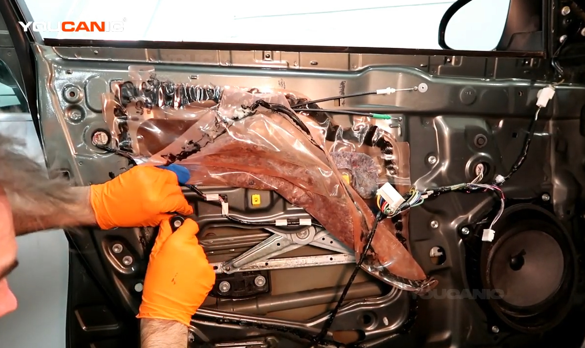 Removing the bolts holding the window regulator.