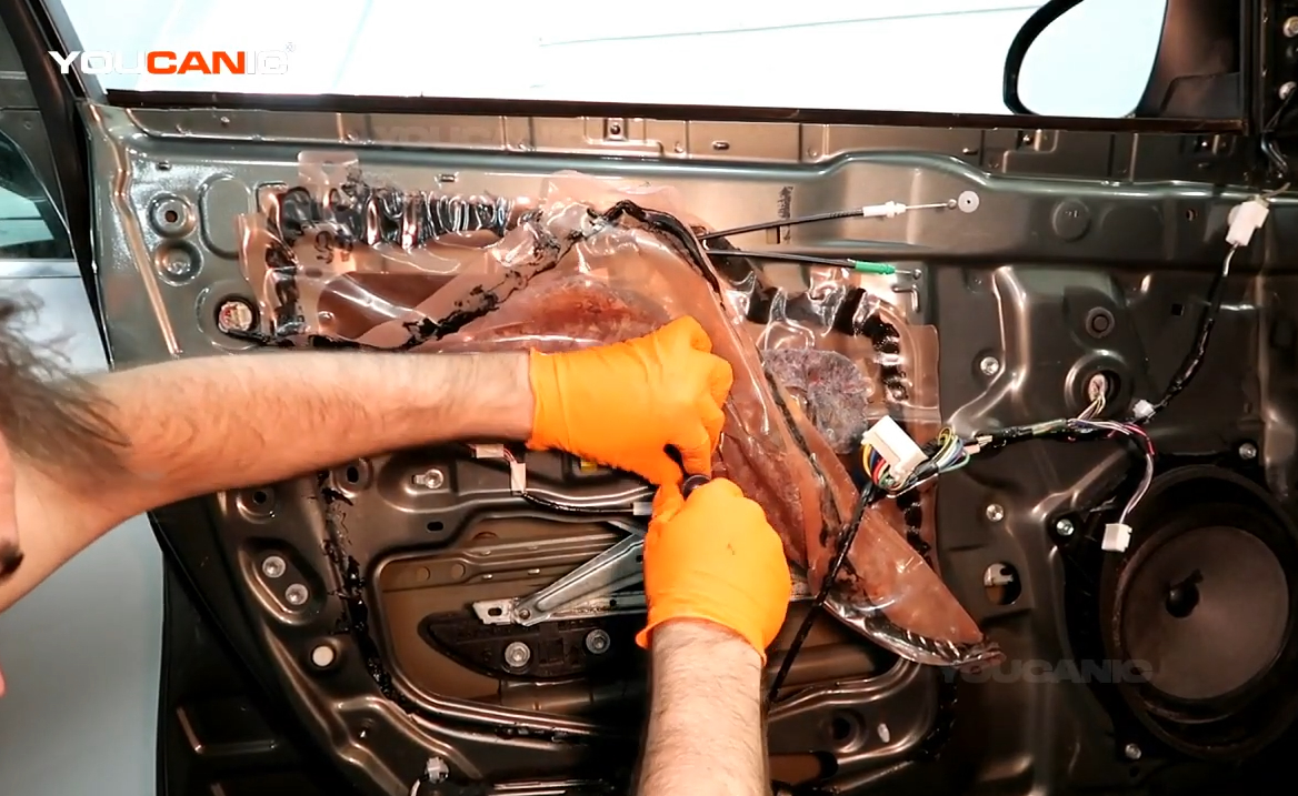 Removing the bolts holding the window regulator.