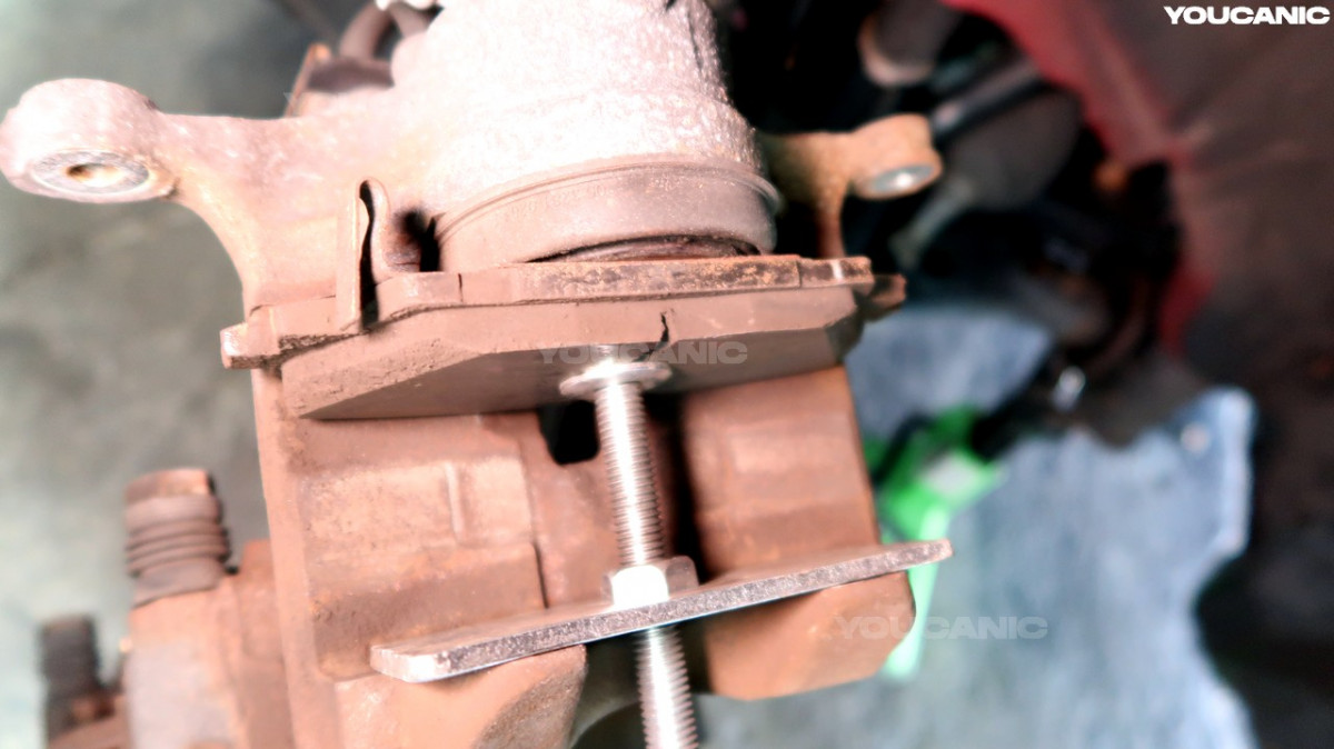Pushing the piston on the piston caliper using a piston compressor.